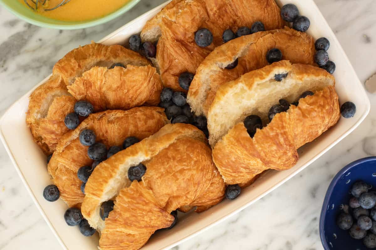 Sliced croissants with blueberries randomly placed.
