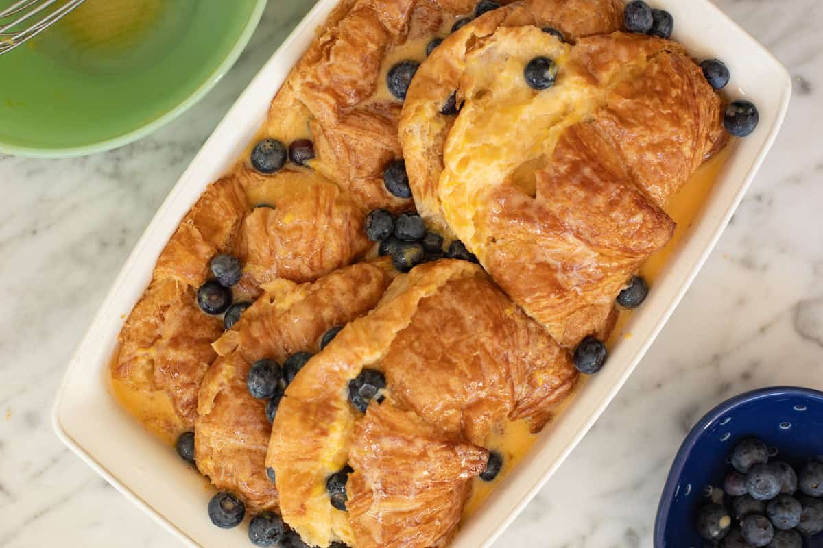 Egg custard poured on the croissant bake.
